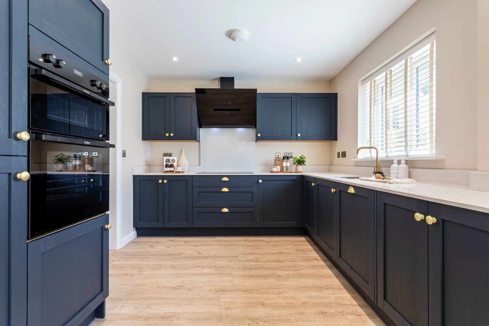 Allison Homes Oakdale show home kitchen with navy shaker cabinets, brass handles and white quartz worktops