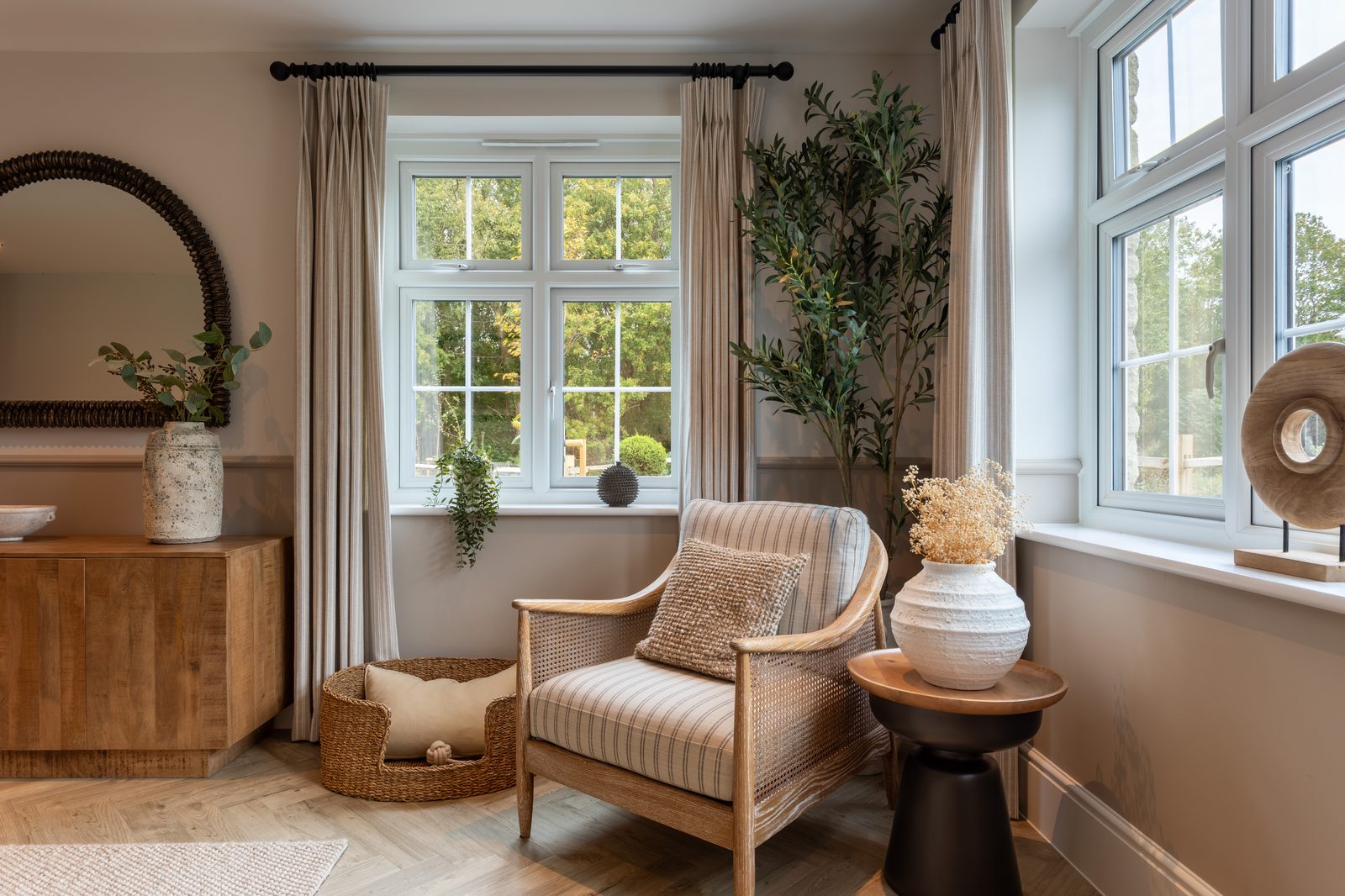 Allison Homes show home snug with rattan armchair, olive tree and herringbone floor