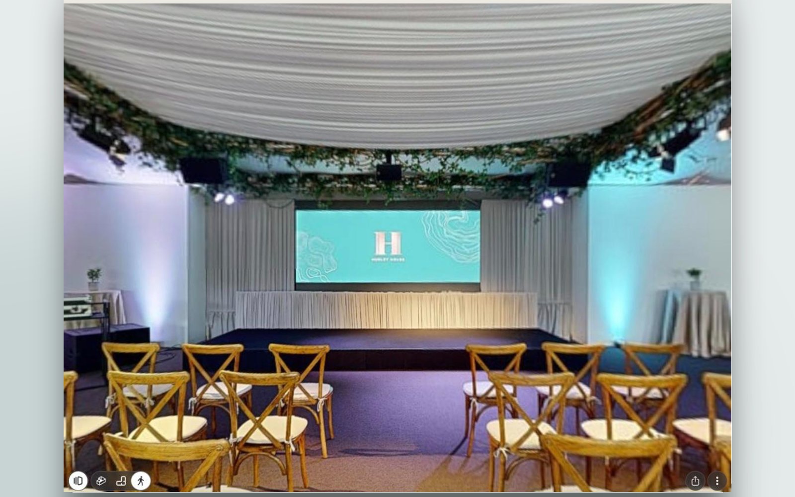 The Garden Pavilion set for a ceremony, with rows of cross-back chairs facing the stage